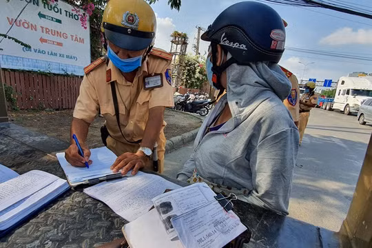 Một người phụ nữ bị CSGT phạt vì mang giấy tờ xe photo dù có chứng thực. Ảnh: Thanh Niên