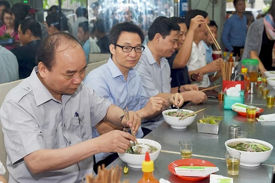 Thủ tướng và đoàn kiểm tra dừng chân, dùng điểm tâm tại một quán ăn đường phố thuộc phường Tân Thành, TPHCM. Ảnh: VGP/Quang Hiếu. 