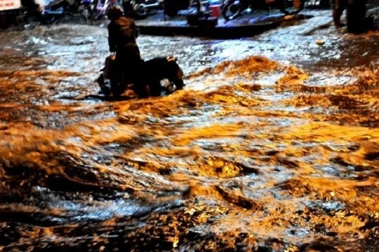 Người dân TP. HCM "bơi" trên đường khi triều cường - (Nguồn Internet)