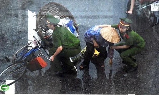 Các chiến sĩ công an giúp đỡ cụ già bị ngã xe giữa đường