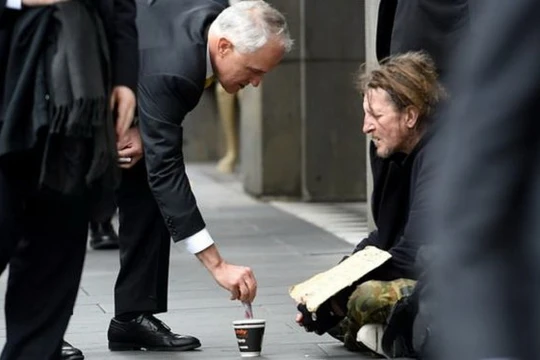 Ông Malcolm Turnbull cho tiền người ăn xin trên đường phố Melbourne hôm 18/8 - Ảnh: AAP