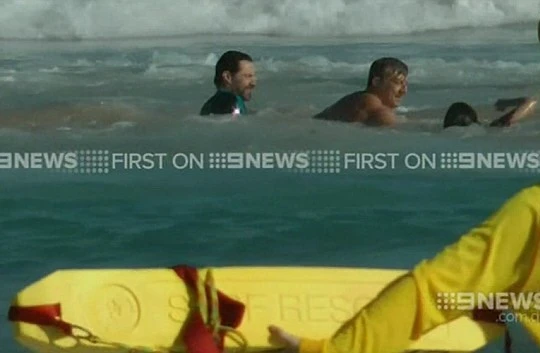 Hugh Jackman đưa một người lướt sóng vào bờ. 