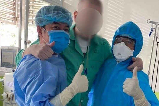 Bệnh nhân 91 đứng dậy tập đi với sự hỗ trợ các bác sĩ BV Chợ Rẫy (Ảnh: N.L.)