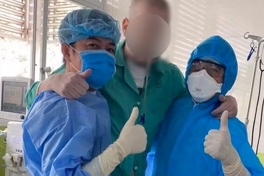 Bệnh nhân 91 đứng dậy tập đi với sự hỗ trợ các bác sĩ BV Chợ Rẫy (Ảnh: N.L.)