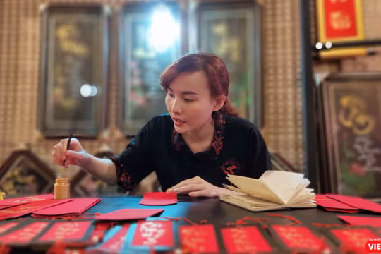 Một nữ thư pháp gia còn rất trẻ đang cho chữ tại phố ông đồ trước Nhà văn hóa Thanh niên 