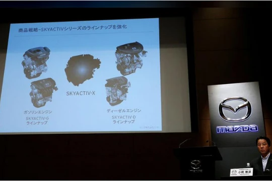 Chủ tịch hãng Mazda Masamichi Kogai bên cạnh màn hình giới thiệu động cơ mới tại cuộc họp báo ở Tokyo ngày 8/8. Ảnh Reuters