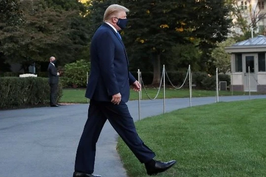 Tổng thống Trump đi bộ đến trực thăng ở Nhà Trắng để vào viện ngày 2/10 (ảnh: Reuters).