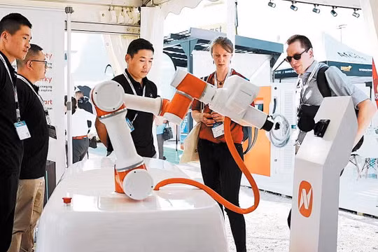 Các nhân viên công ty Công nghệ NaaS Trung Quốc, giới thiệu robot sạc di động trong triển lãm Power2Drive Europe ở Đức tháng 6/2023. Ảnh China Today