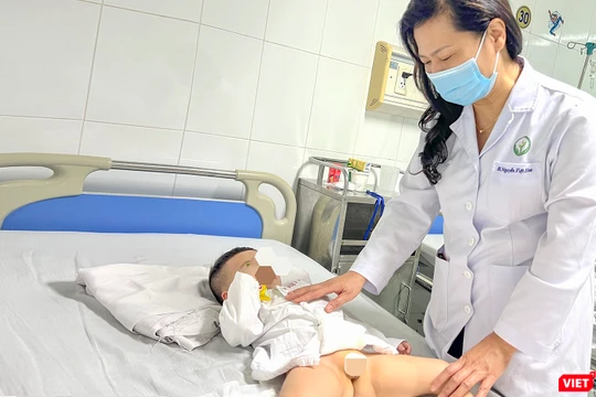 PGS.TS.BS Nguyễn Việt Hoa - Trưởng khoa Phẫu thuật Nhi và Trẻ sơ sinh, Bệnh viện Hữu nghị Việt Đức thăm khám cho bệnh nhân sau ca phẫu thuật (ảnh BVCC)