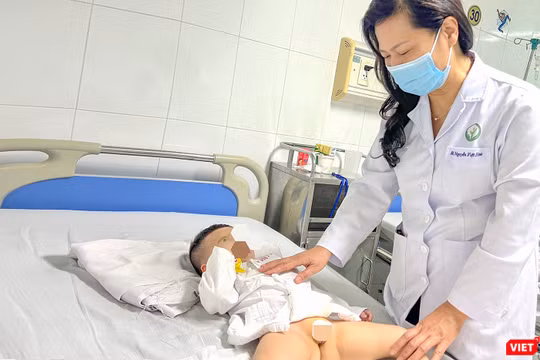 PGS.TS.BS Nguyễn Việt Hoa - Trưởng khoa Phẫu thuật Nhi và Trẻ sơ sinh, Bệnh viện Hữu nghị Việt Đức thăm khám cho bệnh nhân sau ca phẫu thuật (ảnh BVCC)