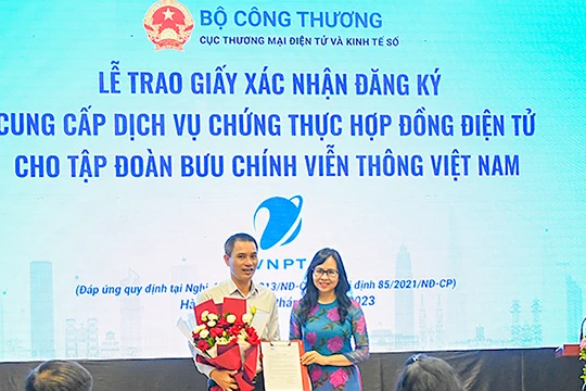 Bà Lê Hoàng Oanh – Cục trưởng Cục thương mại điện tử và Kinh tế số - trao giấy xác nhận đăng ký cung cấp dịch vụ chứng thực hợp đồng điện tử cho đại diện VNPT (ảnh VNPT)