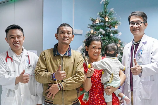 Bố và mẹ bé K.N, cùng bác sĩ điều trị trong niềm vui trước ngày ra viện