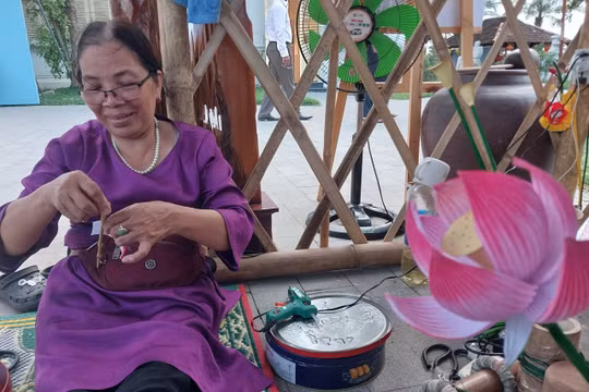 Nghệ nhân làng hoa giấy Thanh Tiên (Thừa Thiên Huế) trình diễn kỹ thuật làm hoa sen 