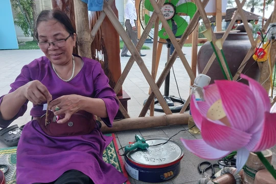 Nghệ nhân làng hoa giấy Thanh Tiên (Thừa Thiên Huế) trình diễn kỹ thuật làm hoa sen 
