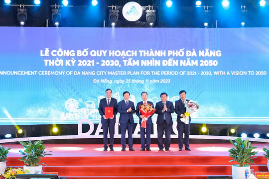 Phó Thủ tướng Chính phủ Trần Hồng Hà (thứ hai từ trái qua) và Bộ trưởng Bộ KH&ĐT Nguyễn Chí Dũng (thứ hai từ phải qua) trao quyết định phê duyệt của Chính phủ Quy hoạch TP Đà Nẵng thời kỳ 2021 - 2030, tầm nhìn đến năm 2050 của Chính phủ cho lãnh đạo TP Đà Nẵng