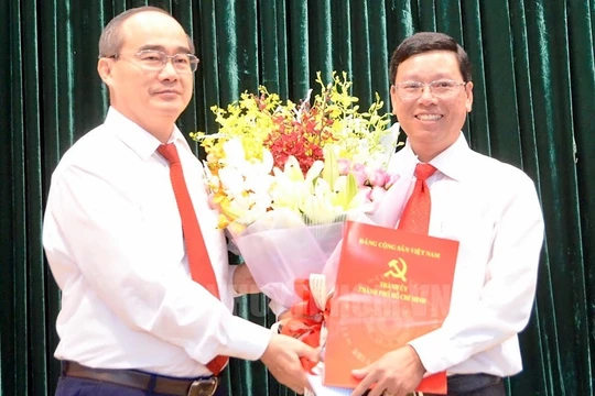 Bí thư Thành ủy TPHCM Nguyễn Thiện Nhân trao quyết định và hoa chúc mừng ông Vũ Ngọc Tuất.