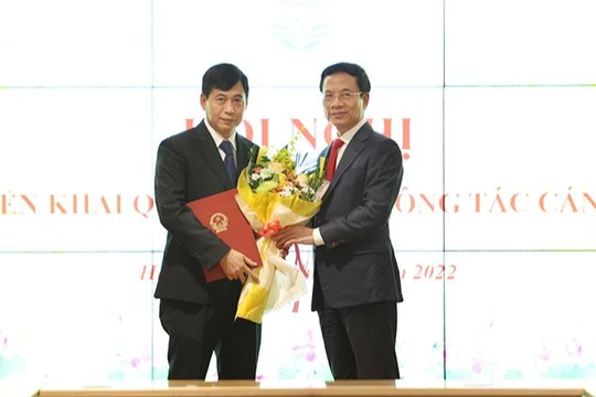 Bộ trưởng Nguyễn Mạnh Hùng trao quyết định và tặng hoa chúc mừng ông Nguyễn Thành Phúc.