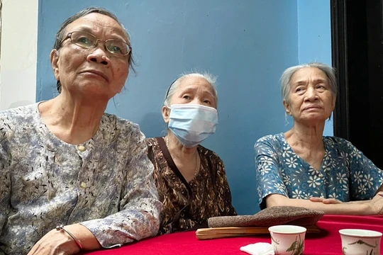 Những người hàng xóm có mặt tại nhà Trung tá Đặng Anh Quân từ sớm, chia sẻ nỗi buồn cùng gia đình (Ảnh: Mạnh Quân)