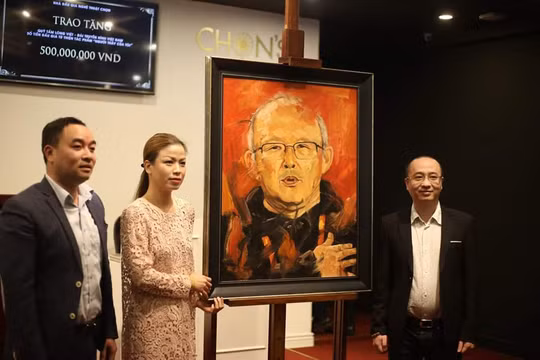 Đại diện Quỹ Tấm Lòng Việt – Đài Truyền hình Việt Nam và ông Nguyễn Phan Huy Khôi bên cạnh bức tranh “Người thầy của tôi” vừa được đấu giá từ thiện thành công, thu 500 triệu đồng từ thiện