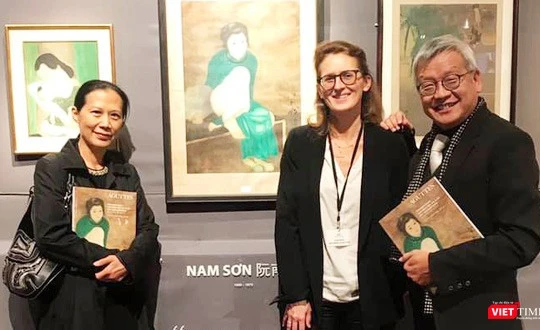 Nhà nghiên cứu Ngô Kim Khôi (bên phải) cạnh bức tranh lụa "Thiếu nữ cầm quạt" của họa sĩ Nam Sơn trưng bày tại Pháp 