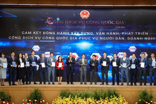 Phó Tổng giám đốc VPBank Đinh Văn Nho (thứ 5 từ trái sang) và các doanh nghiệp ký cam kết đồng hành xây dựng, phát triển Cổng Dịch vụ công quốc gia. (Ảnh: Minh Sơn/Vietnam+)