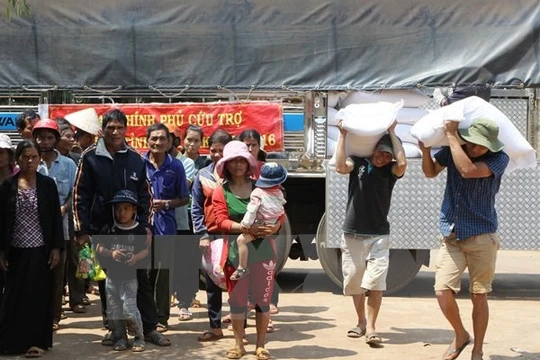 Cấp gạo cho các hộ khó khăn bị ảnh hưởng do hạn hán tại xã Đắk Lắk. (Ảnh: Dương Giang/TTXVN)