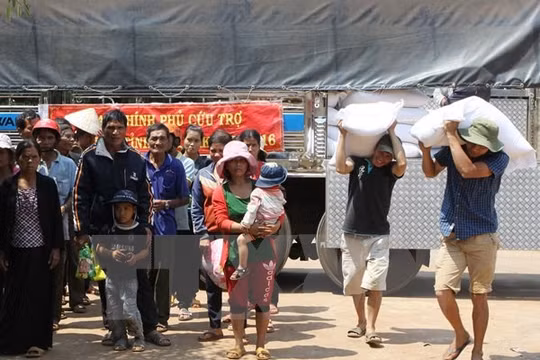 Cấp gạo cho các hộ khó khăn bị ảnh hưởng do hạn hán tại xã Đắk Lắk. (Ảnh: Dương Giang/TTXVN)