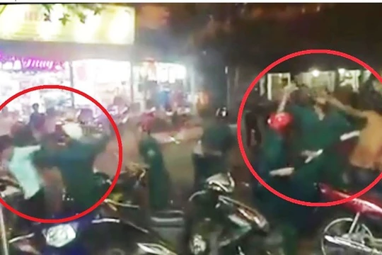Hình ảnh nhóm dân quân dùng dùi cui đuổi đánh các thanh niên. Ảnh cắt từ clip.