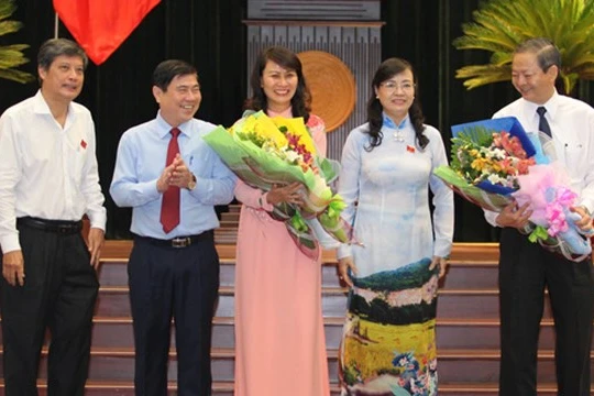 Hai tân Phó chủ tịch UBND TP Nguyễn Thị Thu (giữa) và Lê Văn Khoa (bìa phải) nhận hoa chúc mừng từ Chủ tịch HĐND TP Nguyễn Thị Quyết Tâm (thứ hai từ phải qua) và Chủ tịch UBND TP Nguyễn Thành Phong (thứ hai từ trái qua) - Ảnh: Hoàng Triều