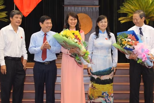 Hai tân Phó chủ tịch UBND TP Nguyễn Thị Thu (giữa) và Lê Văn Khoa (bìa phải) nhận hoa chúc mừng từ Chủ tịch HĐND TP Nguyễn Thị Quyết Tâm (thứ hai từ phải qua) và Chủ tịch UBND TP Nguyễn Thành Phong (thứ hai từ trái qua) - Ảnh: Hoàng Triều