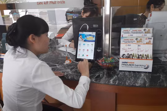 Nhân viên LienVietPostBank đang thực hành sử dụng máy tính bảng để giới thiệu cho khách hàng