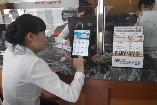 Nhân viên LienVietPostBank đang thực hành sử dụng máy tính bảng để giới thiệu cho khách hàng