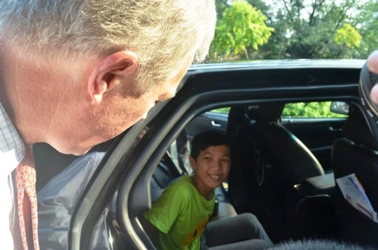 Ông Ted Osíu mời em Tuấn, một trẻ em làng trẻ SOS, ngồi vào và giới thiệu về chiếc xe đặc biệt của Đại sứ quán Mỹ, tại Việt Nam chỉ có 2 chiếc