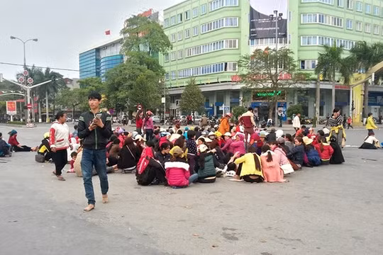 Người dân Sầm Sơn ngồi la liệt dưới lòng đường ngã tư đại lộ Lê Lợi - Trần Phú. Ảnh: Nguyễn Dương.