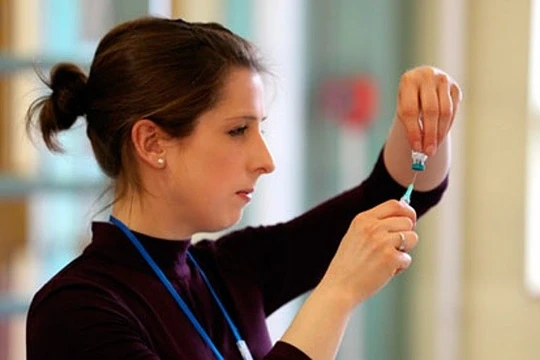 Một y tá chuẩn bị tiêm ngừa vắc xin cho trẻ tại Anh. Ảnh: Athena