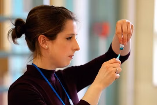 Một y tá chuẩn bị tiêm ngừa vắc xin cho trẻ tại Anh. Ảnh: Athena