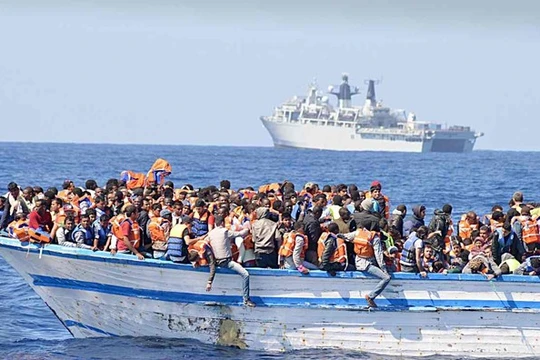 Hàng trăm người di cư chen chúc trên một thuyền nhỏ ở ngoài khơi Libya. Ảnh: REX