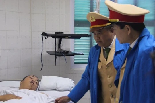 Thiếu tướng Trần Sơn Hà và lãnh đạo Phòng CSGT Hà Nội thăm hỏi thượng úy Đạt. Ảnh: N.H.