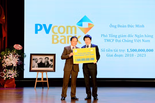Ông Đoàn Đức Minh – Phó Tổng Giám đốc PVcomBank trao số tiền tài trợ học bổng cho sinh viên ĐH Kinh tế Quốc dân.