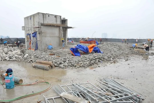 Thực hiện phá dỡ phần công trình xây dựng sai phạm tại tòa nhà 8B Lê Trực. (Ảnh: Minh Đức/TTXVN)