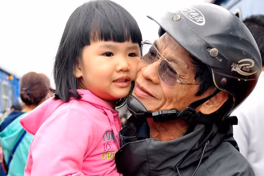 Ông Trần Thẩm (70 tuổi, ngụ thị trấn Sông Vệ, huyện Tư Nghĩa) mừng vui ôm cháu ngoại theo mẹ vừa về cho thỏa nỗi nhớ mong sau một năm dài xa cách. "Cuộc sống dẫu còn nhiều khó khăn nhưng mỗi dịp xuân về, vợ chồng tôi đều đi xe máy vượt hơn 15 km từ quê ra