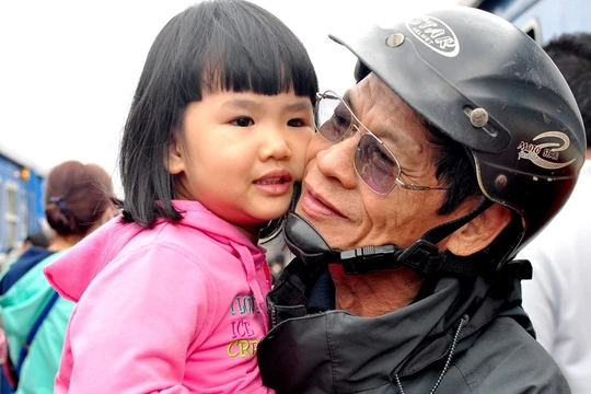 Ông Trần Thẩm (70 tuổi, ngụ thị trấn Sông Vệ, huyện Tư Nghĩa) mừng vui ôm cháu ngoại theo mẹ vừa về cho thỏa nỗi nhớ mong sau một năm dài xa cách. "Cuộc sống dẫu còn nhiều khó khăn nhưng mỗi dịp xuân về, vợ chồng tôi đều đi xe máy vượt hơn 15 km từ quê ra