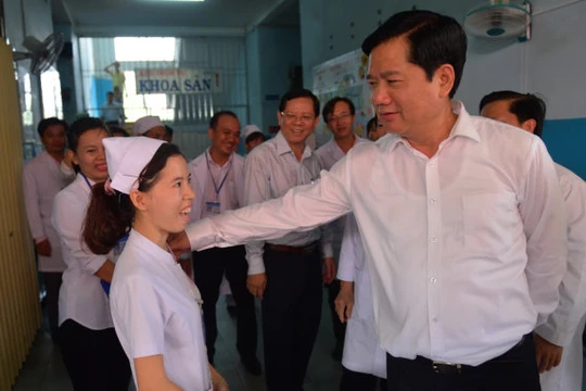 Bí thư Thành ủy TP.HCM Đinh La Thăng hỏi thăm một y tá đang công tác tại bệnh viện sáng 5-6 - Ảnh: QUANH ĐỊNH