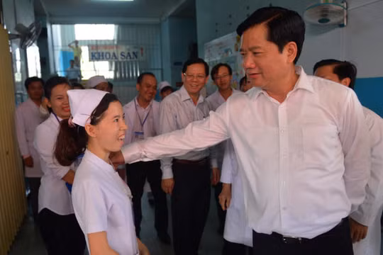 Bí thư Thành ủy TP.HCM Đinh La Thăng hỏi thăm một y tá đang công tác tại bệnh viện sáng 5-6 - Ảnh: QUANH ĐỊNH