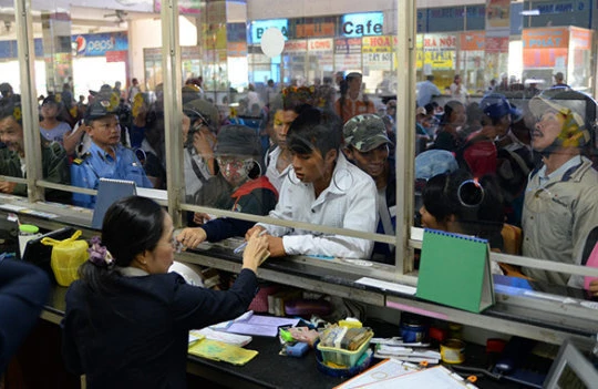 Hành khách mua vé tại bến xe miền Đông - Ảnh: TTO