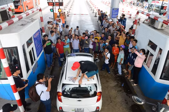 Tài xế Võ Mạnh Hảo dừng xe lau kính giữa trạm thu phí. Ảnh: Zing