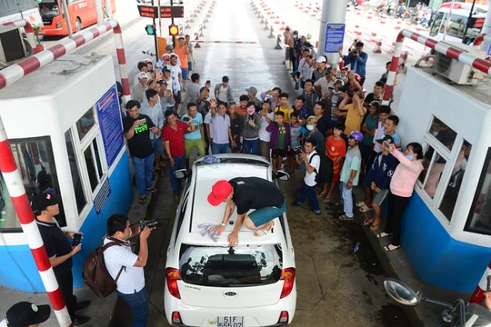 Tài xế Võ Mạnh Hảo dừng xe lau kính giữa trạm thu phí. Ảnh: Zing