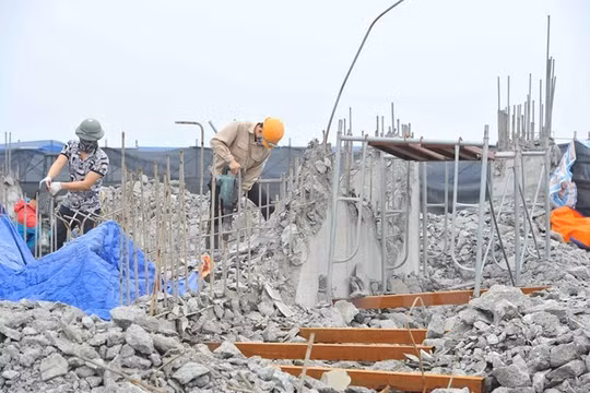 Công nhân tiến hành khoan, phá dỡ phần công trình xây dựng trái phép ở toà nhà số 8B Lê Trưc, Hà Nội, sáng 6/3. (Ảnh: Minh Đức/TTXVN)