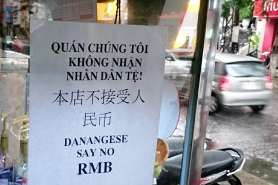 Nhạc sĩ Nguyễn Duy Khoái treo bảng thông báo không nhận Nhân dân tệ ngay trước quán nước của mình. Ảnh: H. Long. 