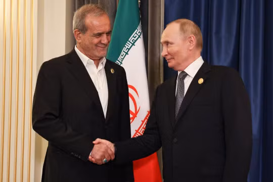 Tổng thống Nga Vladimir Putin và Tổng thống Iran Masoud Pezeshkian bắt tay nhau tại một cuộc gặp ở Thượng Hải năm ngoái. Ảnh: TASS.